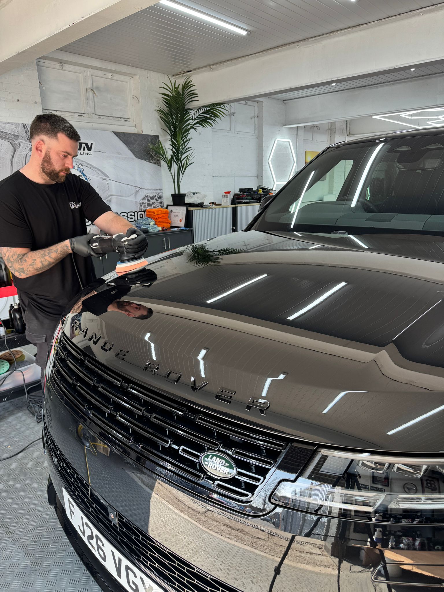 Machine polishing a Range Rover bonnet in the detailing studio