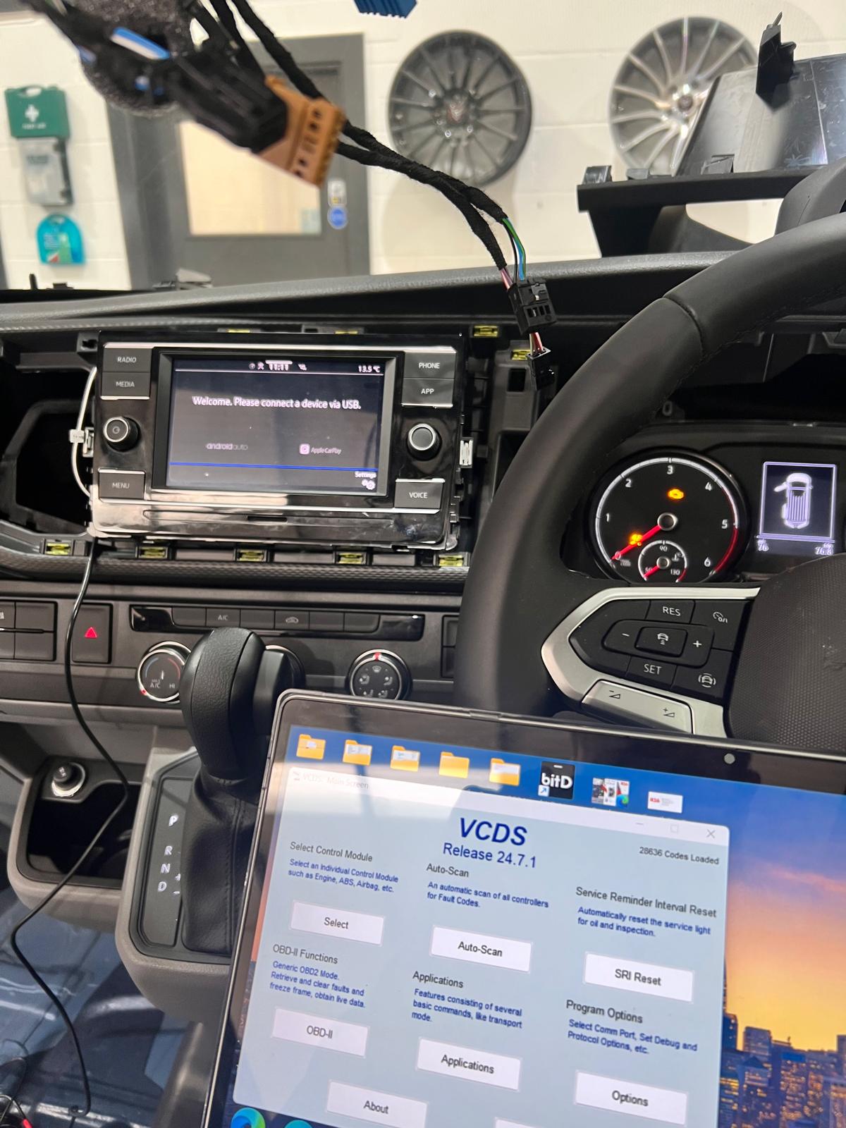 VCDS diagnostic software coding a Volkswagen's factory screen to accept a reversing camera